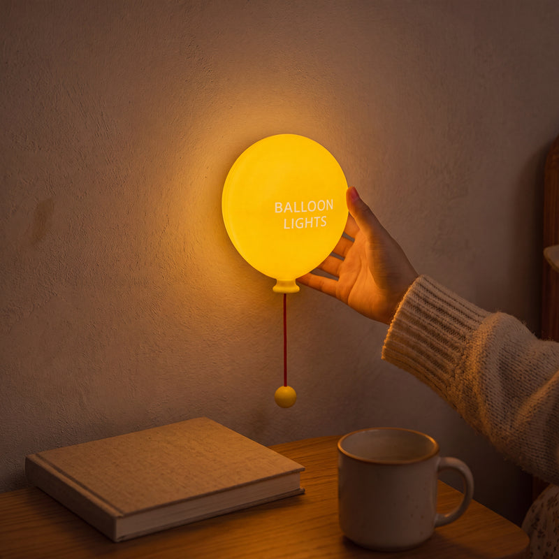 Silicone balloon lamp lighting up a bedside table with soft glow.